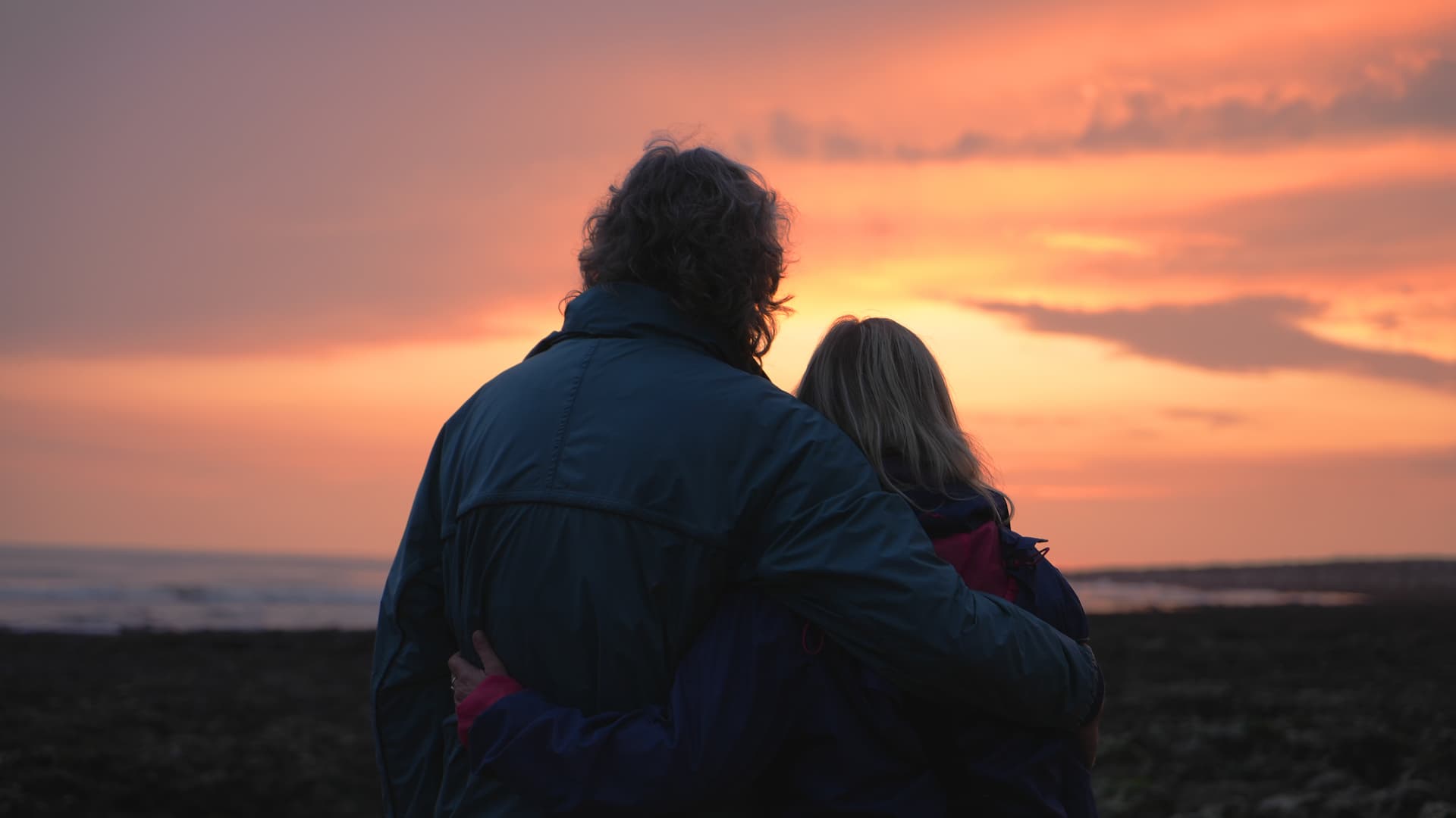 Couple embracing at sunset by the sea
